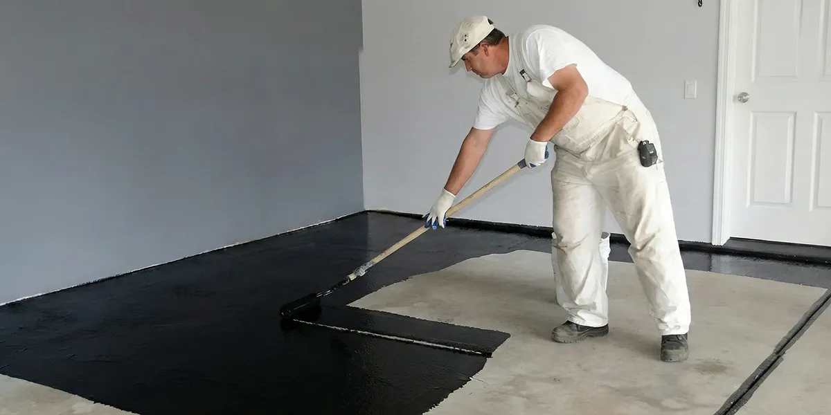 basement waterproofing professional applying waterproof coating to protect a basement floor in West Palm Beach, FL